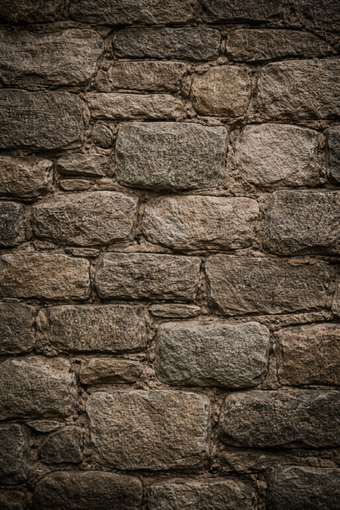Close-up of a weathered stone wall with uneven stones and visible age