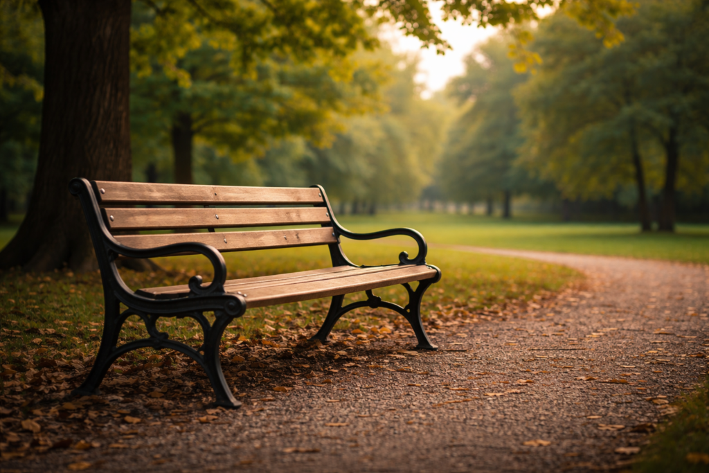 An empty park bench sitting alone in a quiet, open space, suggesting pause and absence.