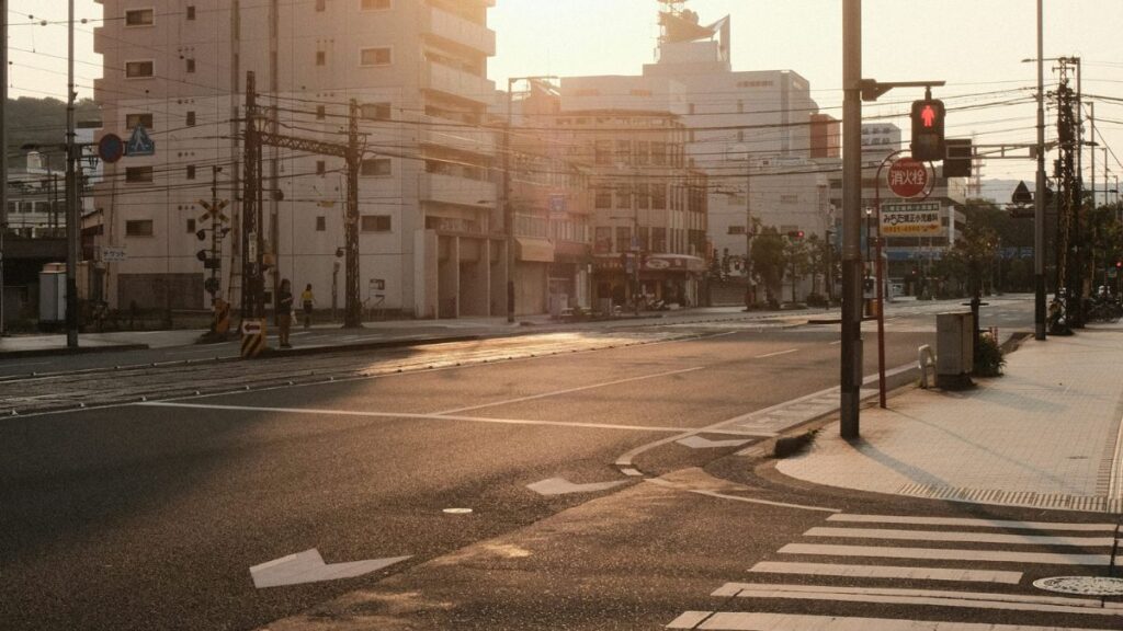 Empty sidewalk in early morning light, city continuing as usual